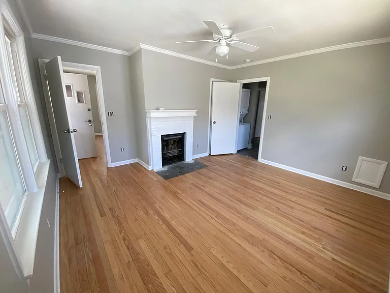 Adorable front bedroom with ceiling fan, quaint mantle over fireplace and restored, BEAUTIFUL 1940's hardwood floors.