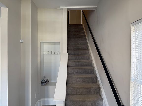 Staircase up to second level, coat rack and nook on the left.