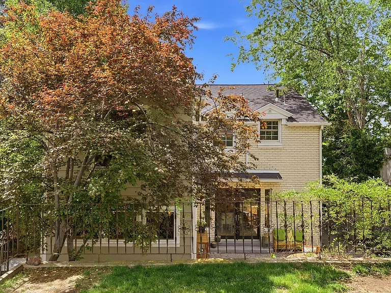 Private back patio and back of the house with mature trees and peaceful garden space.