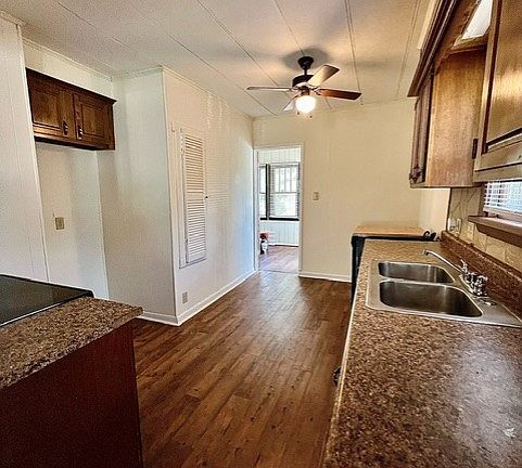View of kitchen looking toward back bedroom through doorway; back door to backyard is on right through the doorway.