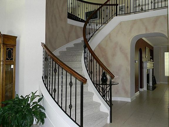Upon entering is the grand staircase with wrought iron railing.