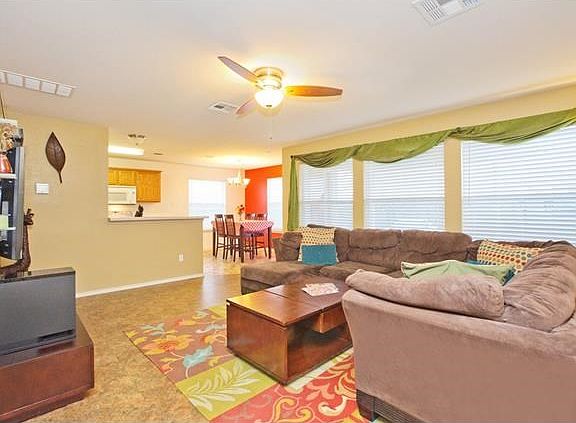 Living area open to kitchen area, dining & windows that overlook backyard covered patio