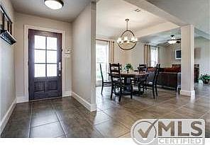 Gorgeous entry! Note large tile flooring, tall baseboards, open