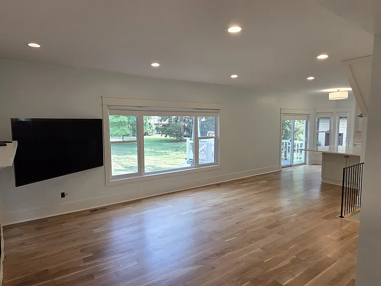 View of living room and sliding door with deck.