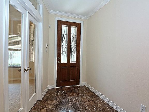 Large open foyer with wood and lead glass front door.