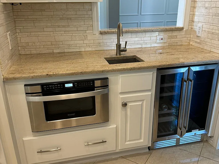 Coffee/wine bar with beverage refrigerator and sink. Also, an undercounter Shark microwave/oven.