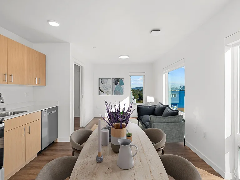 This kitchen and living room feature a table and chairs, offering an open layout and comfortable setting for everyday living.