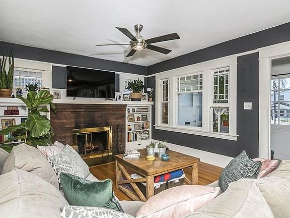 Living room. All windows face west. Built in bookshelves, cabinetry, and windows with historic charm are abundant in the living and dining rooms.