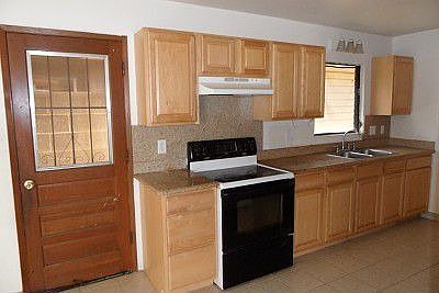 Left side of kitchen has the sink, stove and granite counter tops