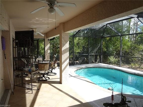 Pool and seating area, in background ample lot with fruit trees.