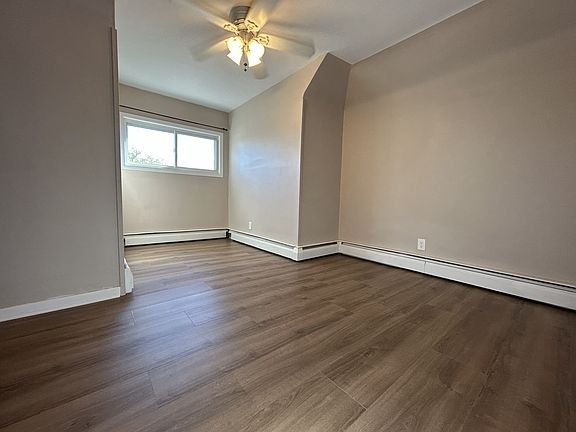 Bedroom 1 with ceiling fan and brand new vinyl flooring.