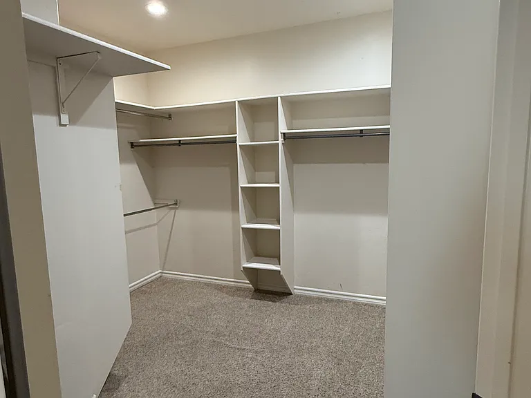 Primary closet with ample built-in shelving