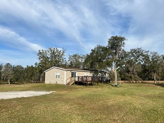 Rear of residence with deck overlooking hay field and wildlife.