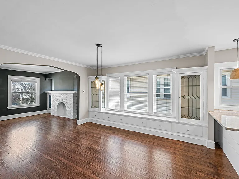 This photo shows the built ins and storage (under bench) available in the dining room. You can also glimpse the decorative fireplace in the living room.