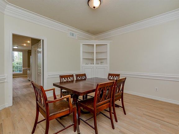 Formal dining with corner built in and elegant crown molding.
