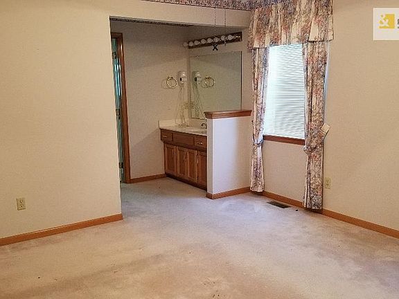 Master Bedroom with vaulted ceiling, fan, walk in closet and divided bath area.  Shower and stool are behind door at end of sink.