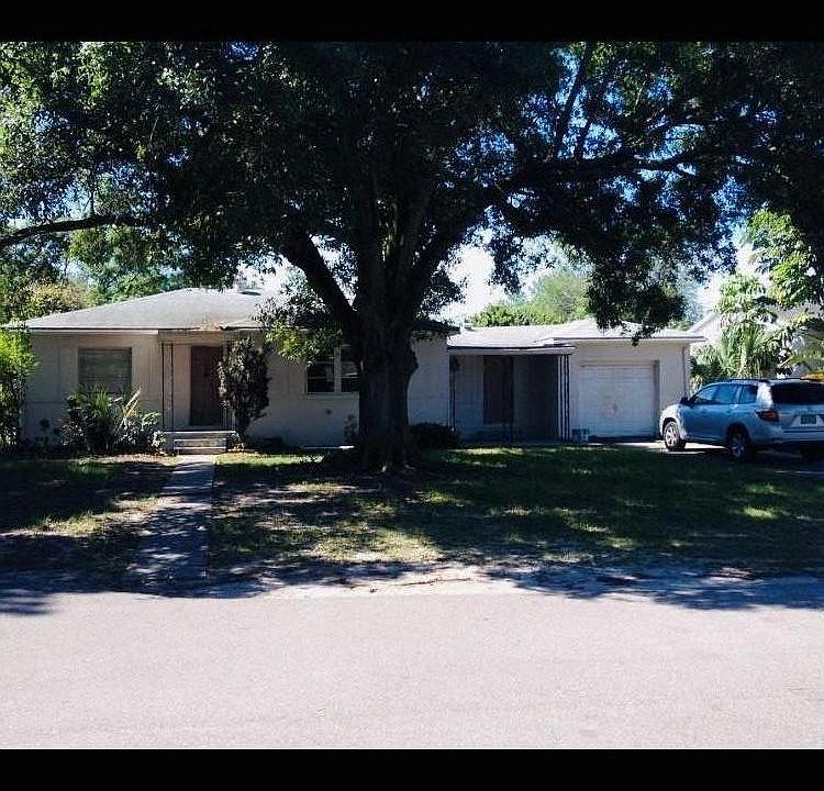 Exterior photo showing front door entrance and one car garage. Note the huge oak tree and the beautiful shade it provides.