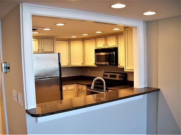view of kitchen from living area. notice granite counter top/bar.