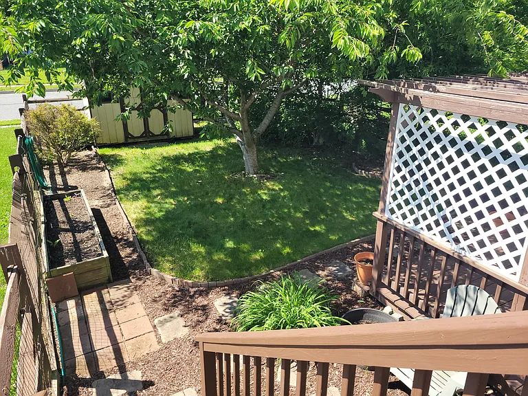 Deck in backyard goes down to shaded backyard and entertainment area. Room to garden