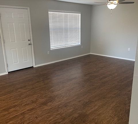 Living room view of the back door, new ceiling fans, new blinds