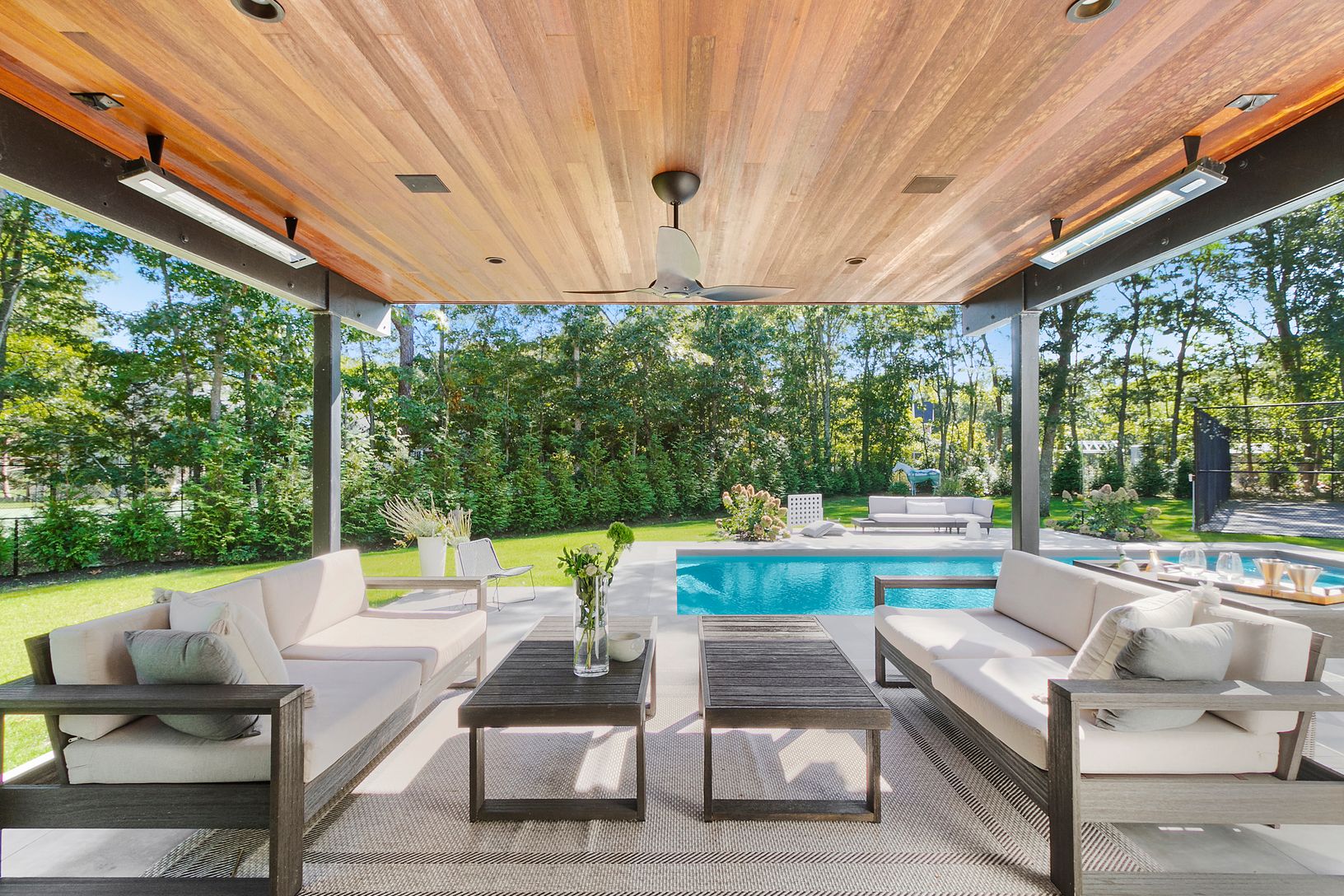 Outdoor covered patio area with built in heat lamps. Fab outdoor kitchen, too
