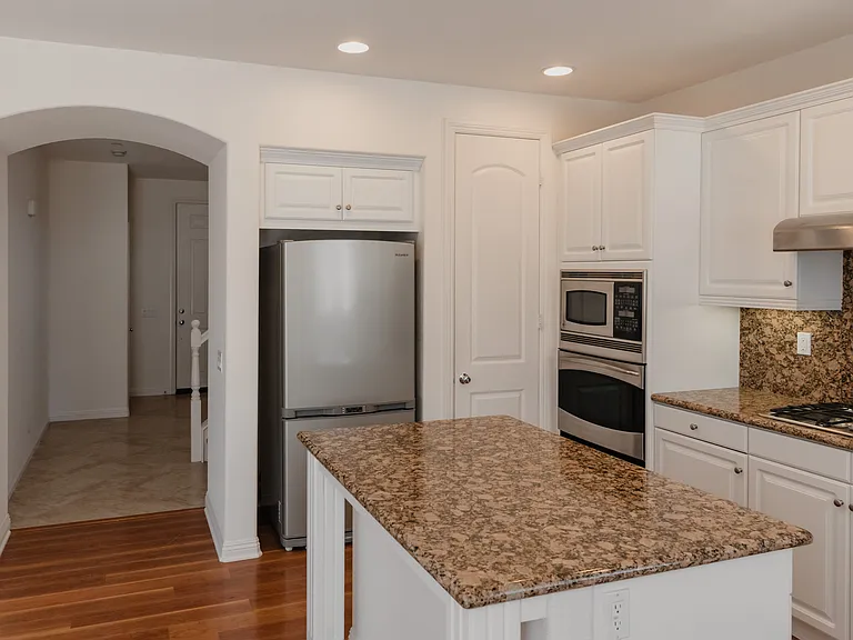 Kitchen with island and stainless steel appliances and view of entryway