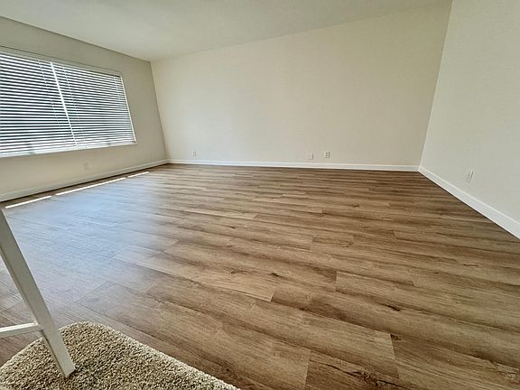Spacious living room with an abundance of lights boast new vinyl plank flooring and new paint!