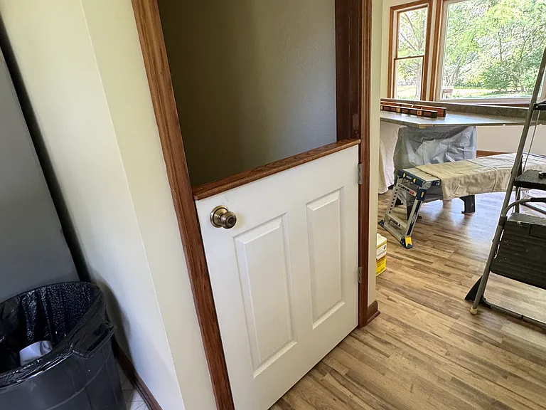 Entrance to living room on the right and kitchen on the left. Half door for basement stairs.
