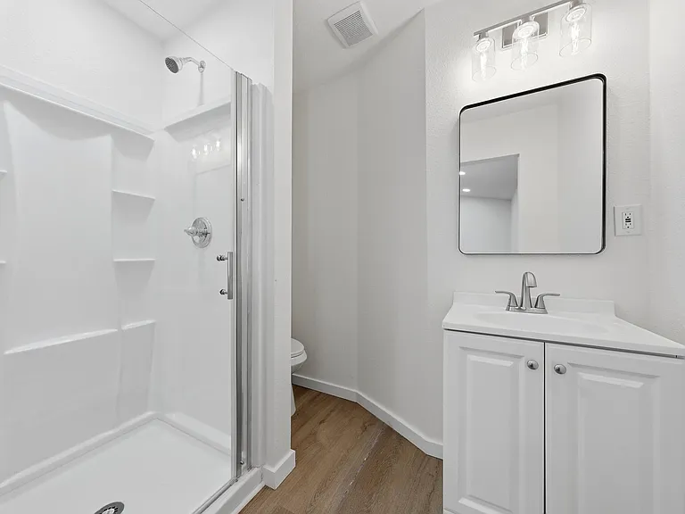 Clean full bath with a walk-in shower, vanity with storage, and updated lighting for easy daily routines.