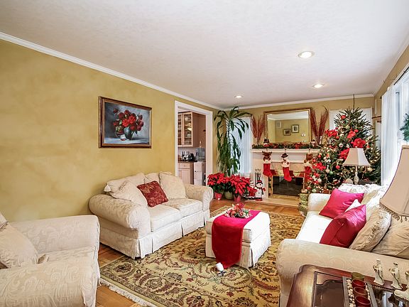 View from entry: Living room with fireplace leading into kitchen