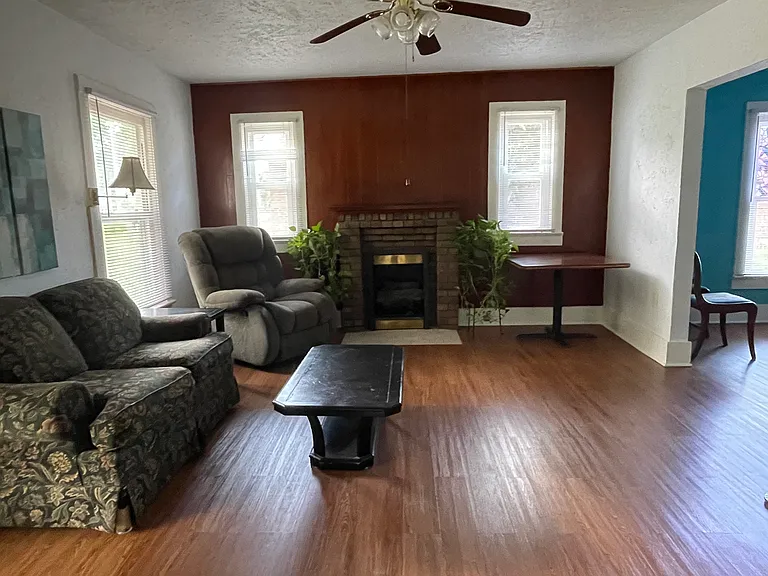Living room with natural light and decorative fireplace.