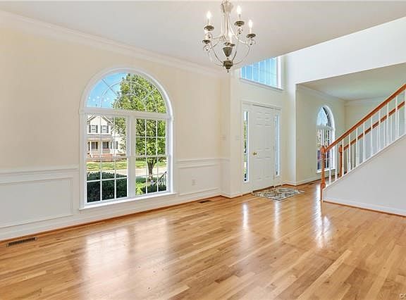 Formal dining room with hardwood floors, crown molding, chair rail, picture frame molding, and beautiful window!