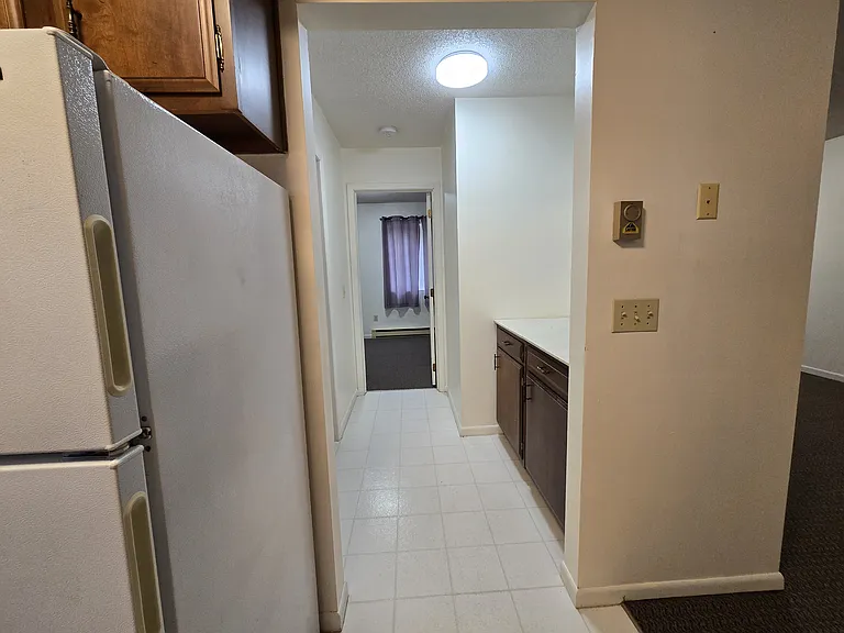 Hallway to bedroom. Multi purpose counter and storage on right