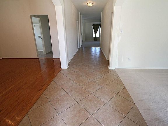 Long entry hallway leading to the living room that's quietly nestled in the back of the home.
