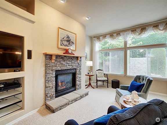 A fireplace adds ambiance to the living room and an adjacent built-in entertainment center is a perfect space saver.>
