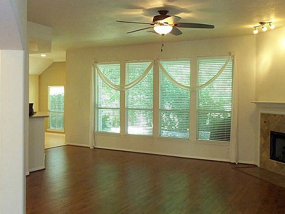 Open concept den with fireplace overlooks backyard