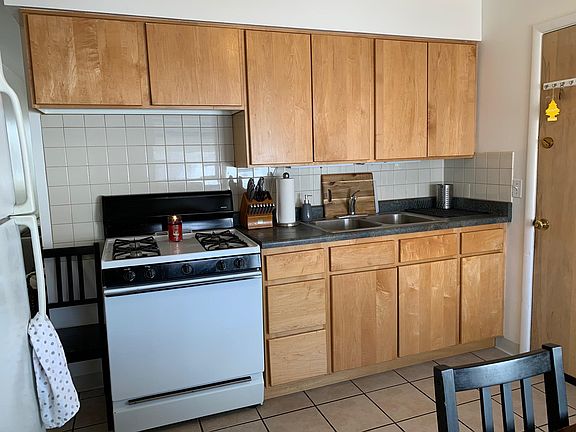 Gas range, fridge and microwave included. Door leads to garage and dedicated laundry/storage room.
