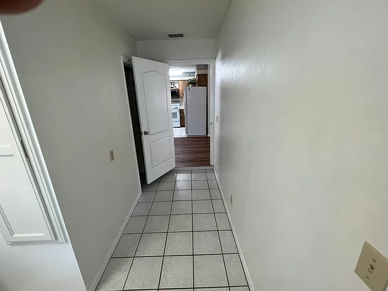 Hallway connecting laundry room to dining room. 2nd bath on left behind door.