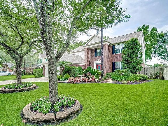 The 2-story covered porch is regal with soaring pillars and decorative door surround. Notice the pretty colorful landscaping. Just perfect!