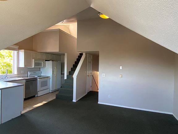 Living room looking back towards bedroom on right and bedroom above plus study space at the top left of stairs