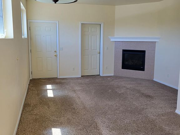 Living room viewed from kitchen with gas fireplace. Storage room to the left of the fireplace (through closed door)
