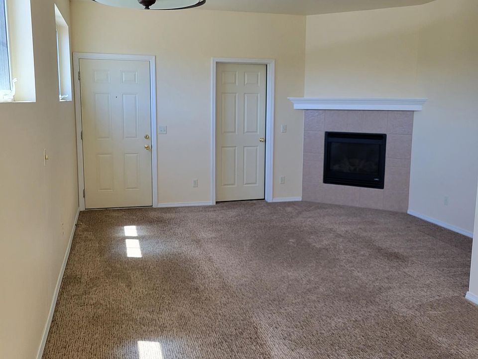 Living room viewed from kitchen with gas fireplace. Storage room to the left of the fireplace (through closed door)