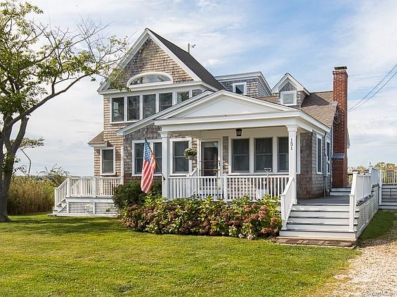 Exterior front picture of 131 Neck Rd in Guilford CT. Notice that the front porch wraps around the home and extends to the back of the home off the kitchen. All decking is TREX.