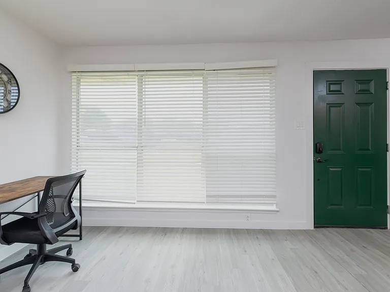 Dedicated workspace with ergonomic chair and wooden desk off of the living room.