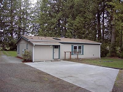 Back of the home showing large paved parking pad.