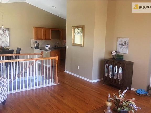 Living room, kitchen and dining area with vaulted ceilings and hardwood floors.