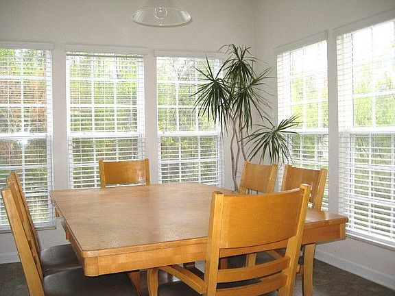 Sun room has nine large windows and looks out to a beautiful natural area.