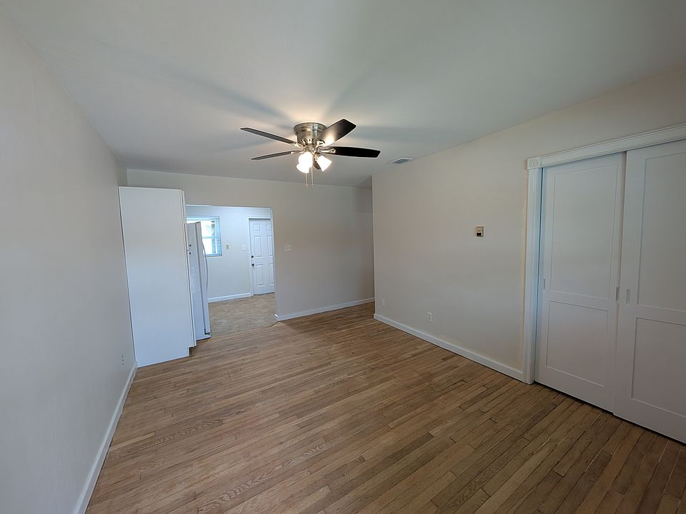 Freshly painted living room with hardwood floors, new ceiling fan and closet.