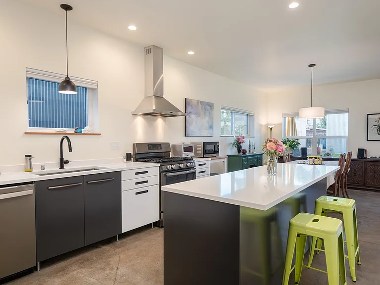Modern kitchen with sleek ebony cabinets and stainless steel appliances.