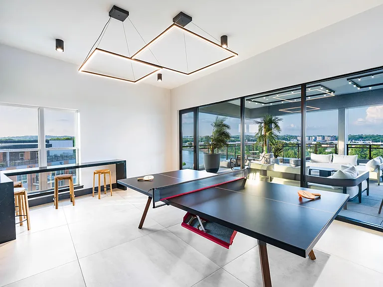 The sky lounge game room invites you to relax and take in sweeping skyline views_whether you're playing ping pong or unwinding on the terrace.